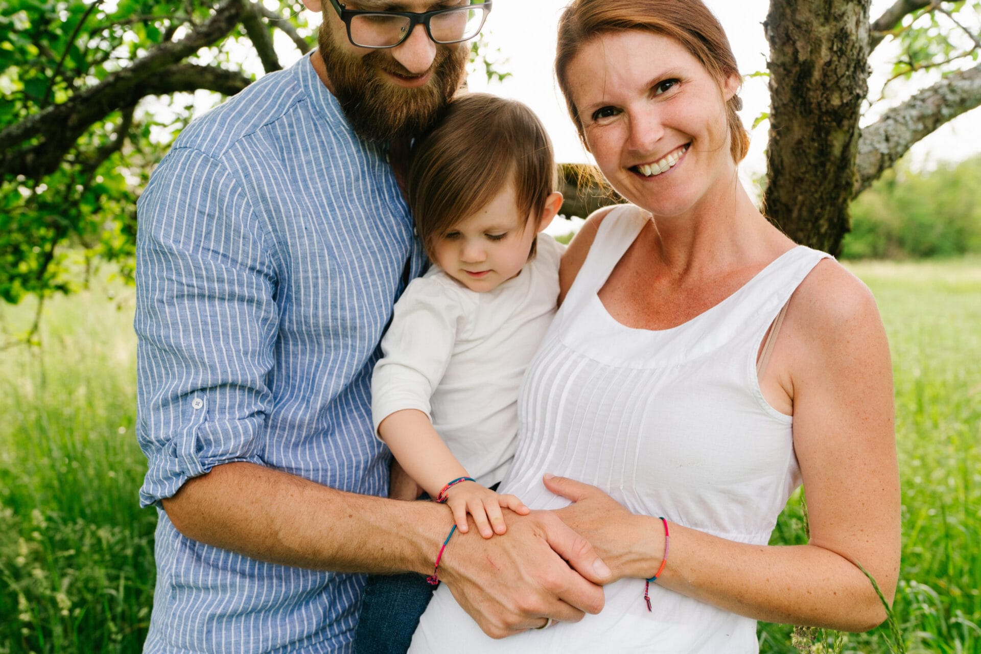 froehliche familienbilder mit babybauch in der natur von aline lange fotografie